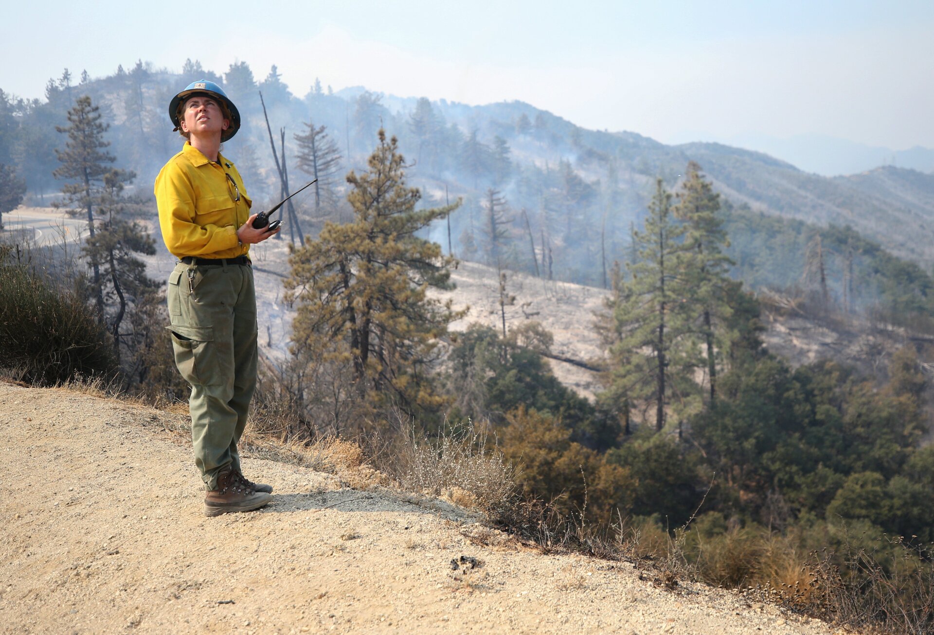 Elizabeth Wright with the Forest Service monitors a firefighting helicopter making water drops during the Bobcat Fire in the Angeles National Forest on Sept. 16, 2020 near Pasadena, California.