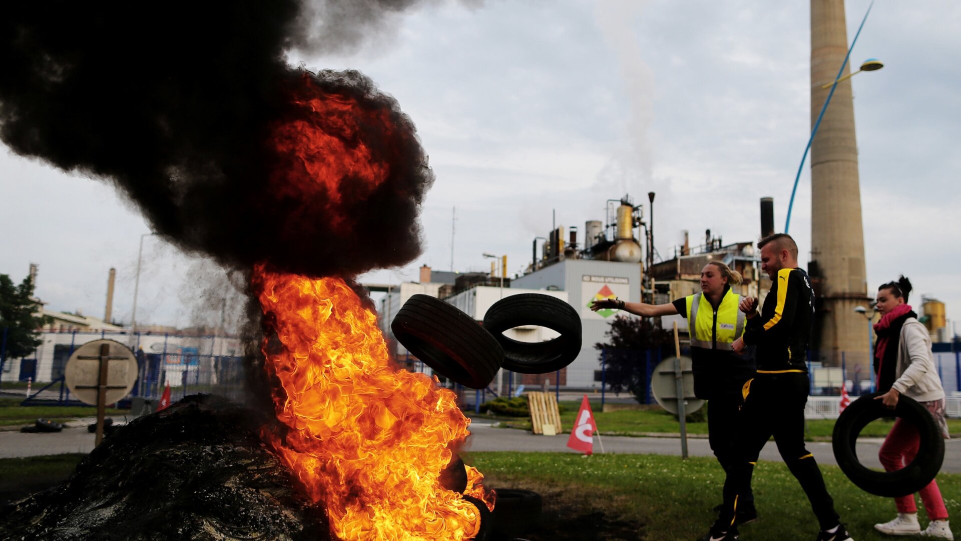 Protesters stoke a fire with tires and block the access to the Exxon Mobil refinery in France. It is also a metaphor for how Exxon treats the atmosphere.