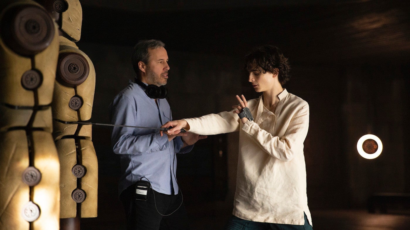Denis Villeneuve works with star Timothée Chalamet on the set of Dune.
