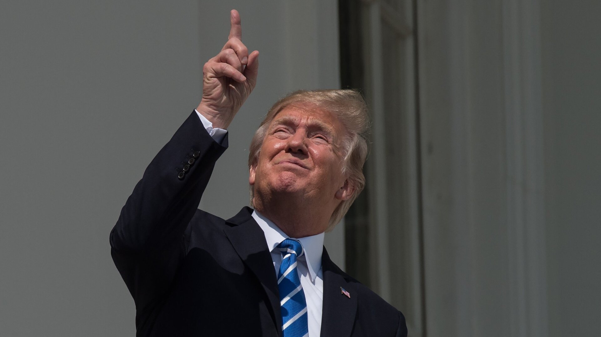 US President Donald Trump looks up at the partial solar eclipse from the balcony of the White House in Washington, DC, on August 21, 2017.