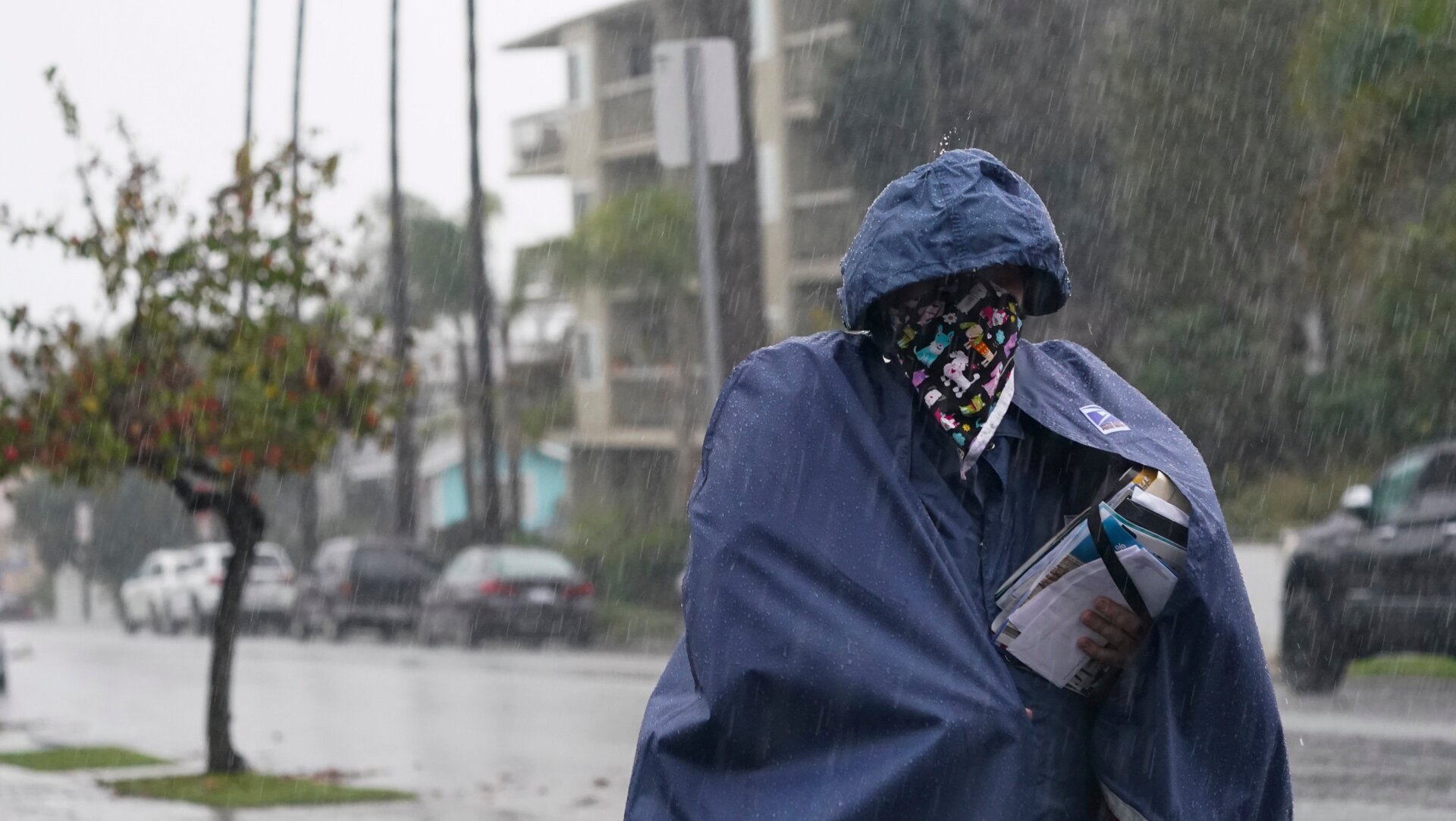 A Postal Service worker delivers mail in the rain in Long Beach, California.