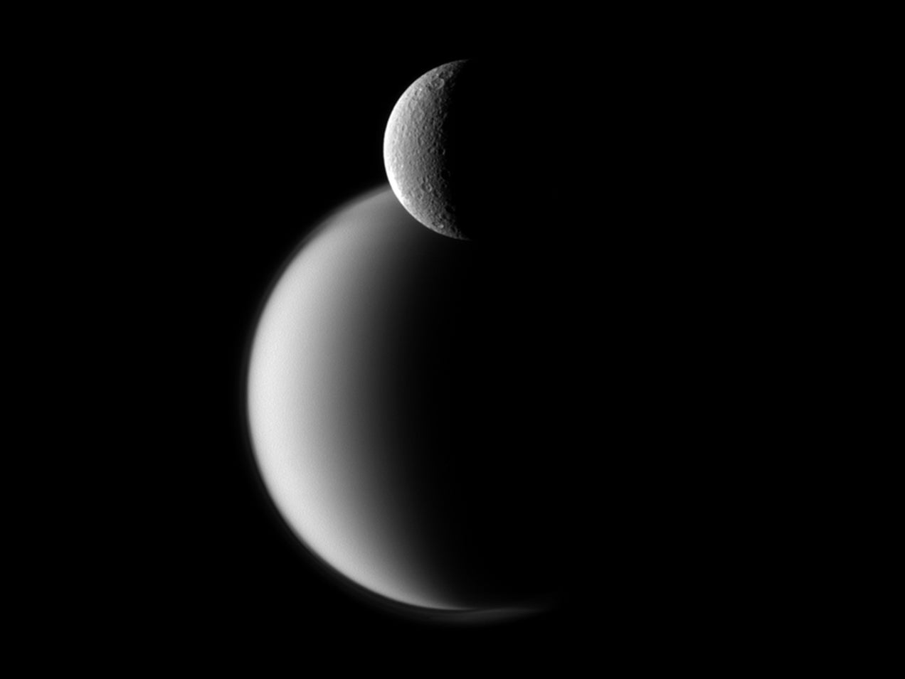 Rhea (front) and the much larger Titan (back).