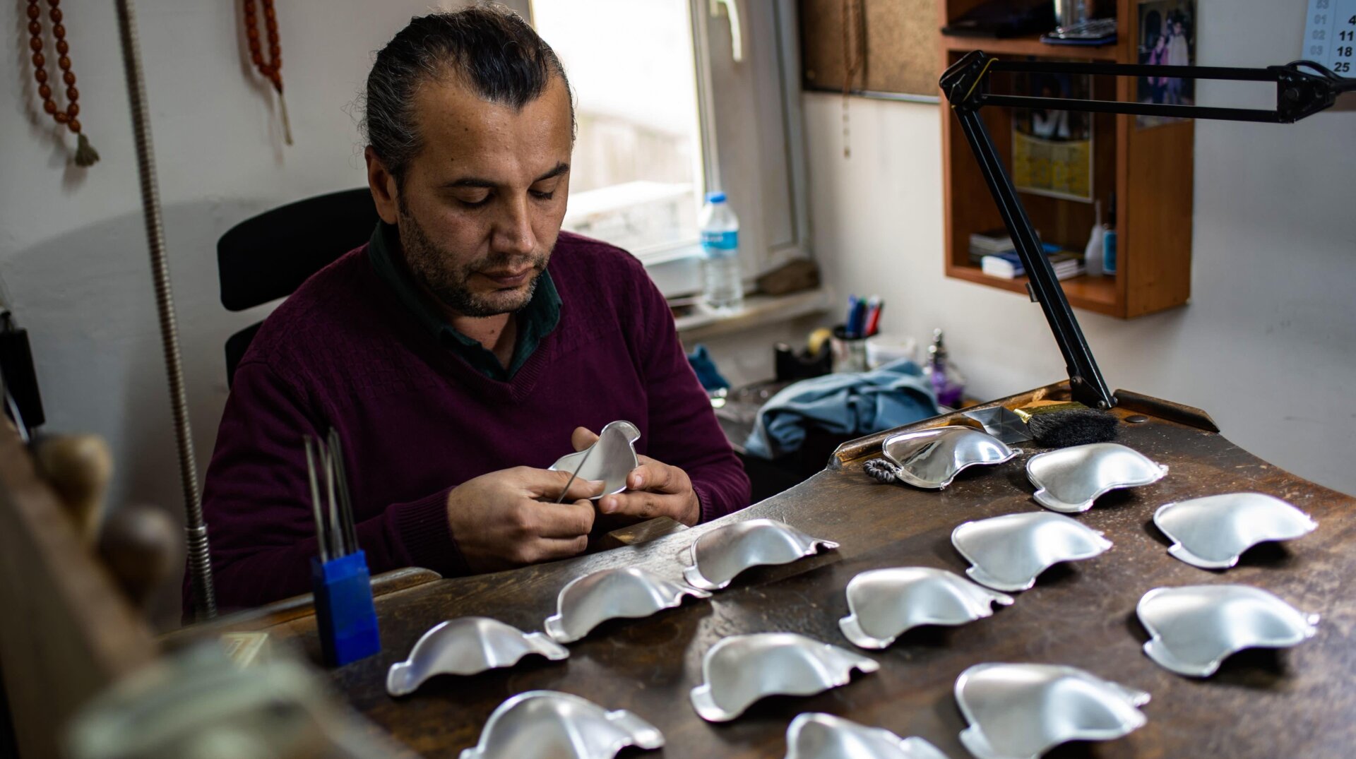 Turkish silver master Sabri Demirci works on his silver and golden protective face masks.