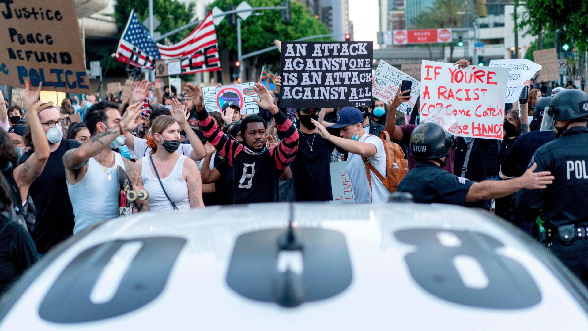 Protesters pass LAPD officers in Los Angeles on June 6, 2020.