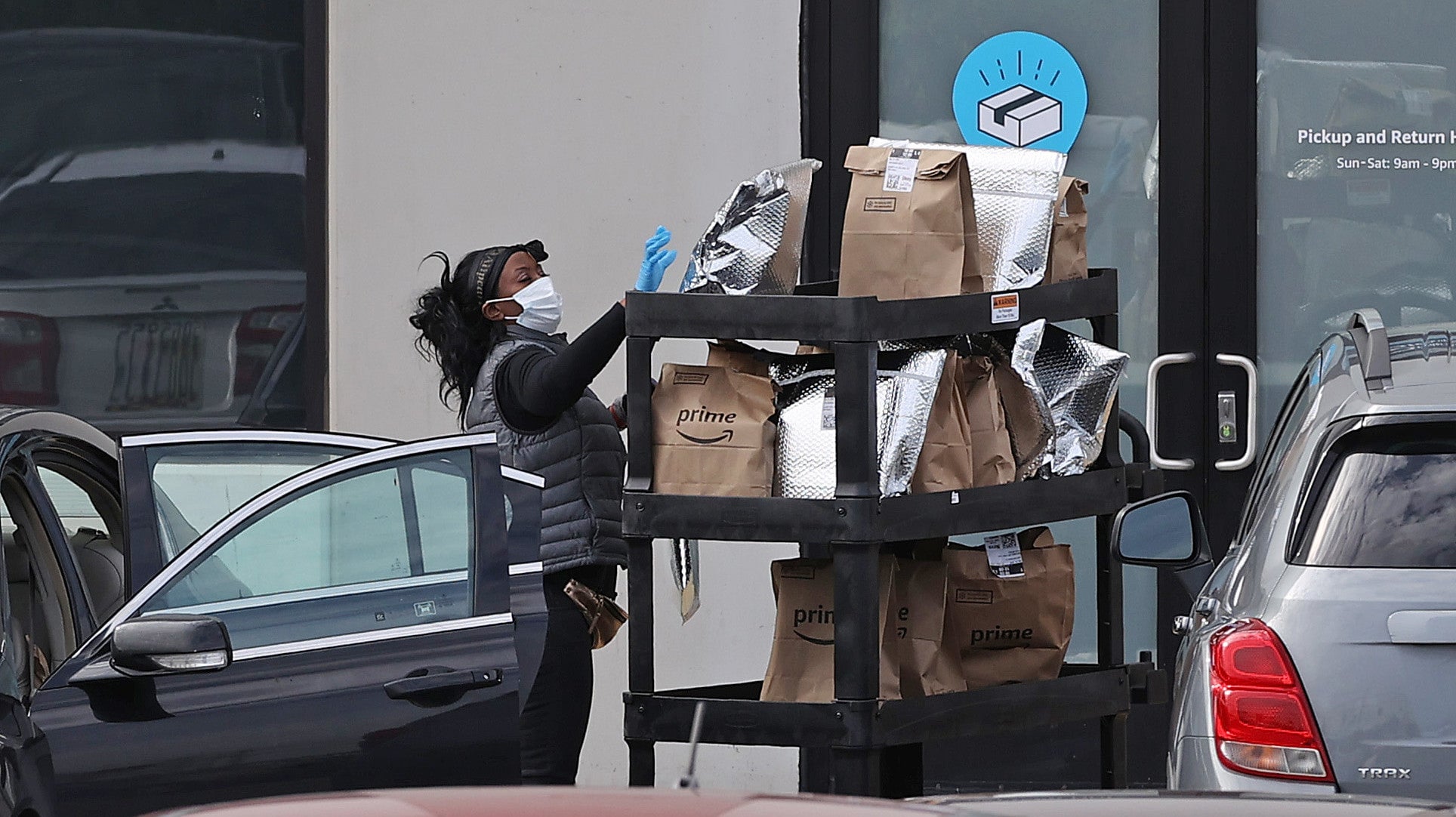 An Amazon Flex driver loads their car with packages outside an Amazon Fulfillment Center.