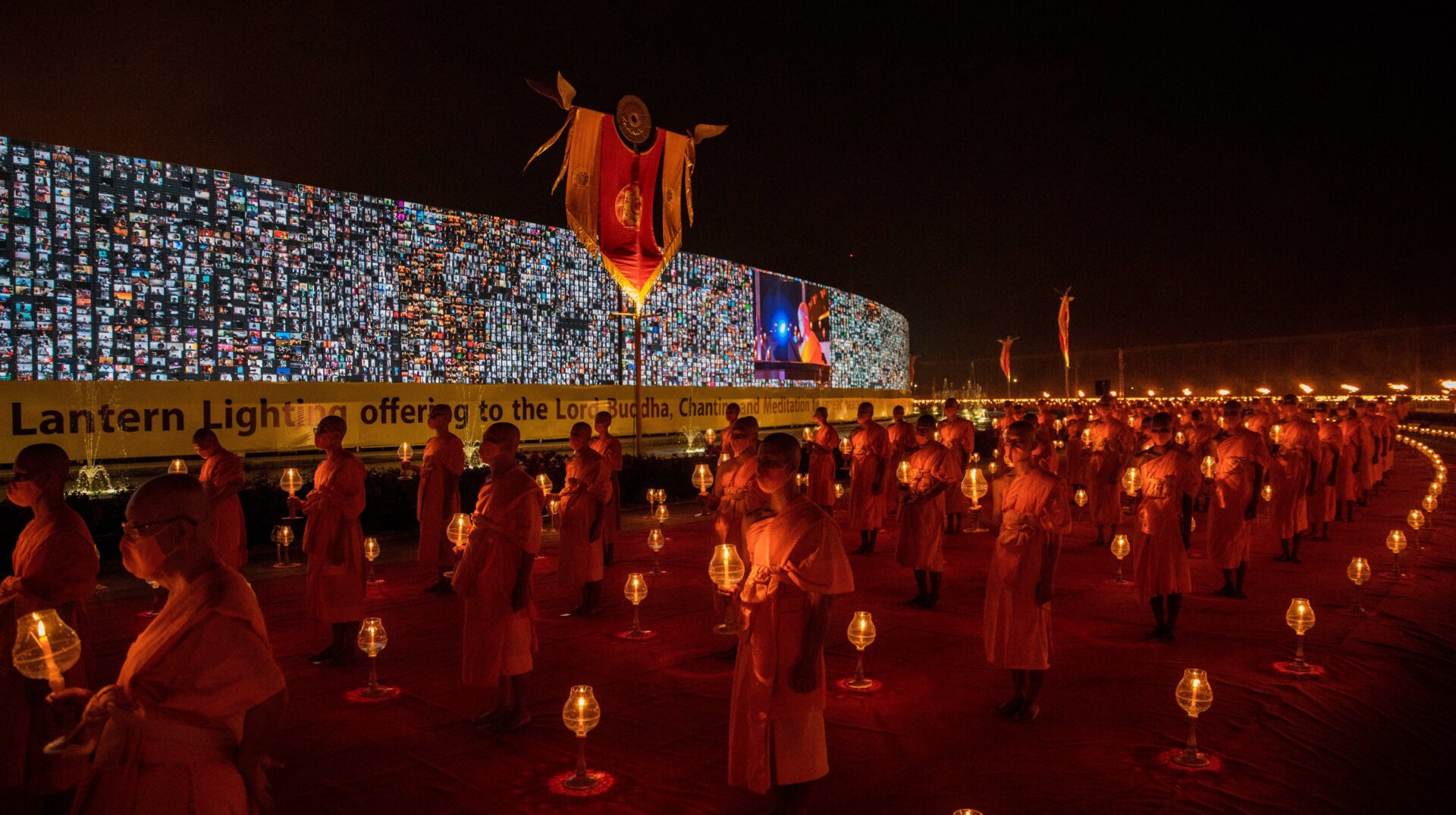 Thai monks walk past a 280-meter-long screen (920 feet) where virtual devotees take part in an online Makha Bucha Day ceremony on February 26, 2021 in Bangkok, Thailand.