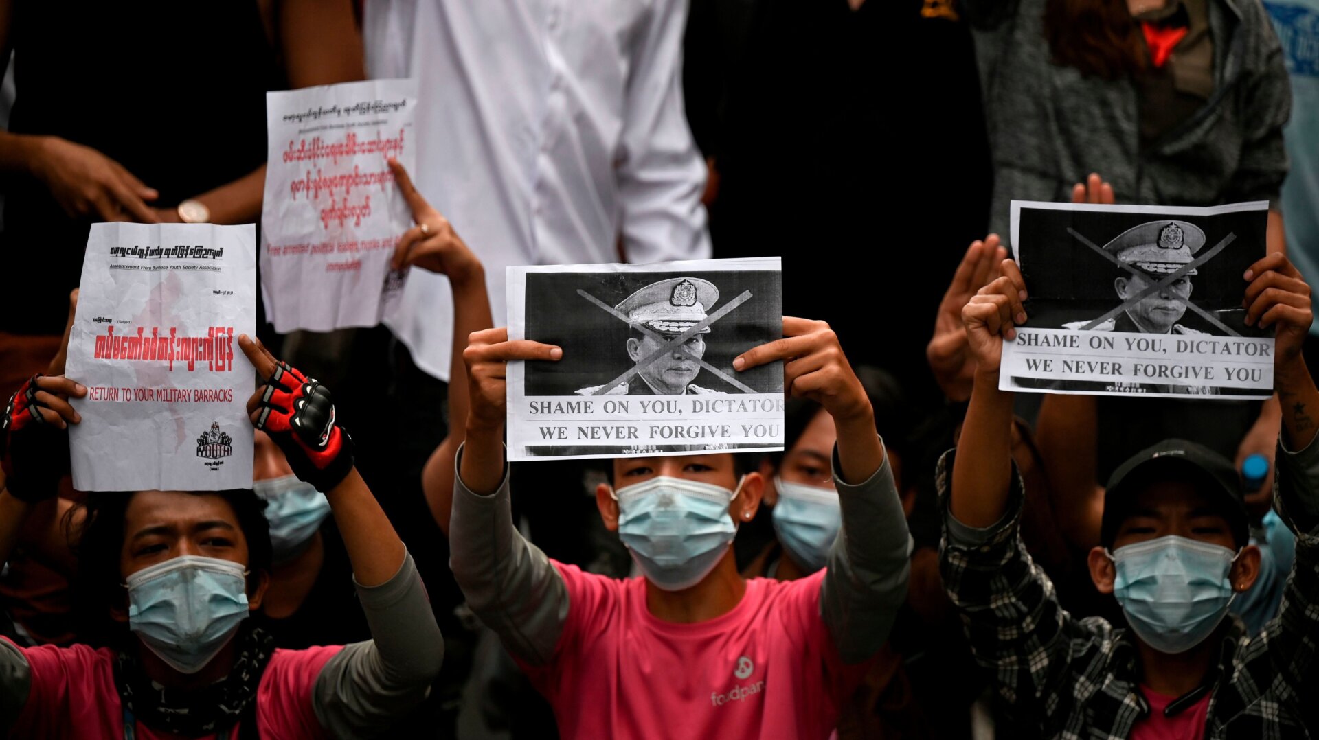 Protesters hold placards during a demonstration against the military coup in Yangon on February 6, 2021.