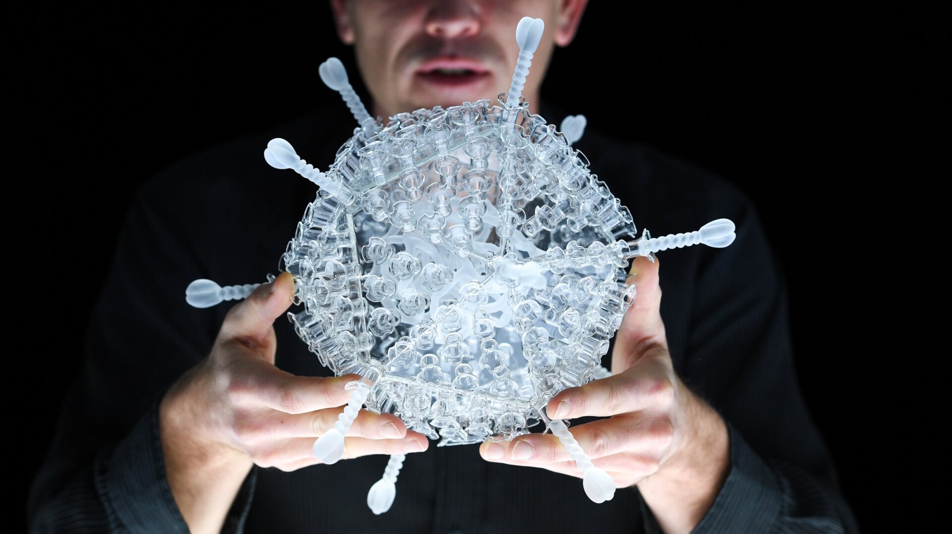 Artist Luke Jerram with his glass sculpture of the Oxford-AstraZeneca coronavirus vaccine at the Paintworks on February 05, 2021 in Bristol, England.
