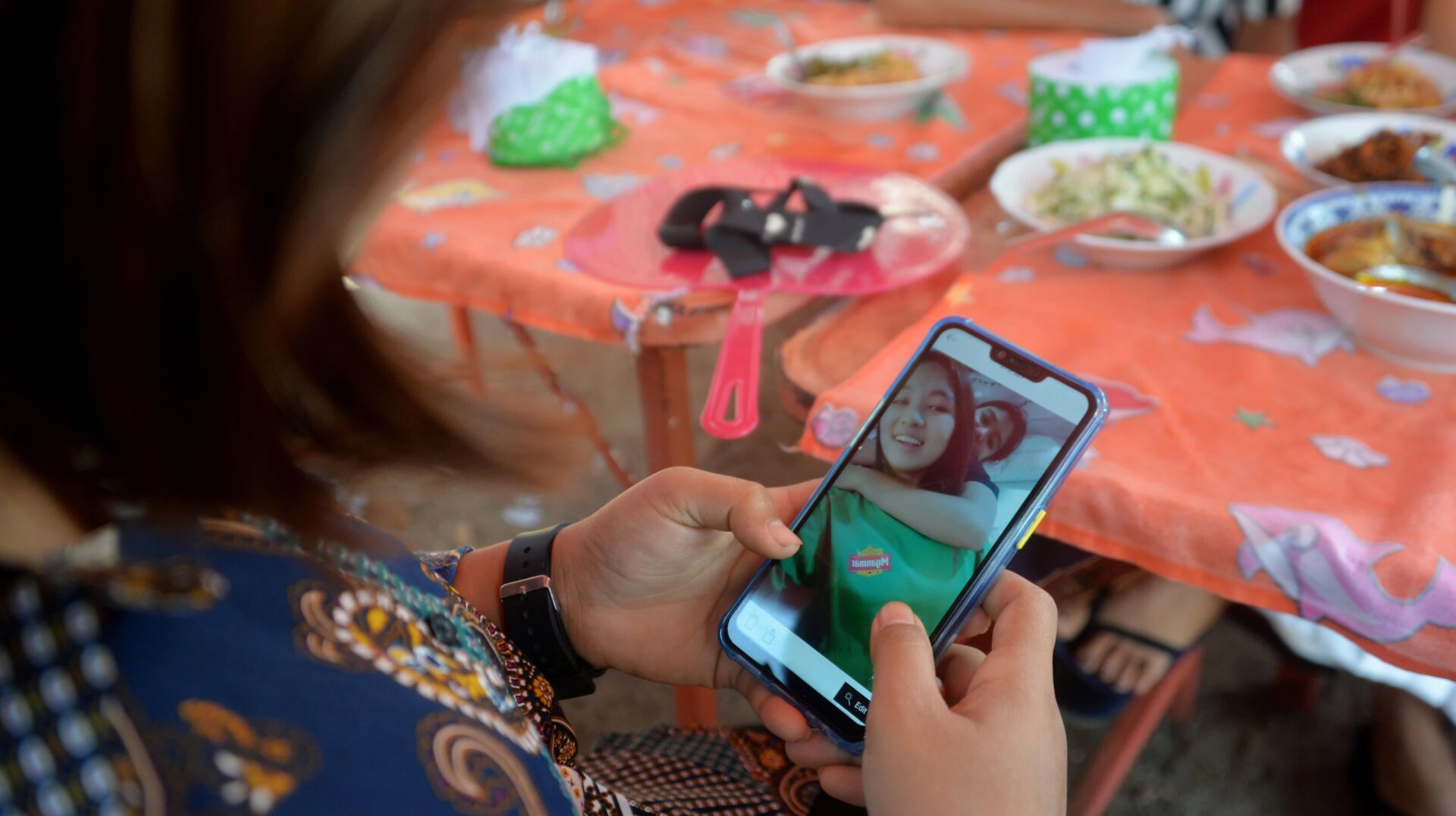 A friend of Myanmar protester Mya Thwate Thwate Khaing, who died after being shot during a rally against the military coup, looks at pictures of her on a phone during a memorial service in Naypyidaw on February 25, 2021.