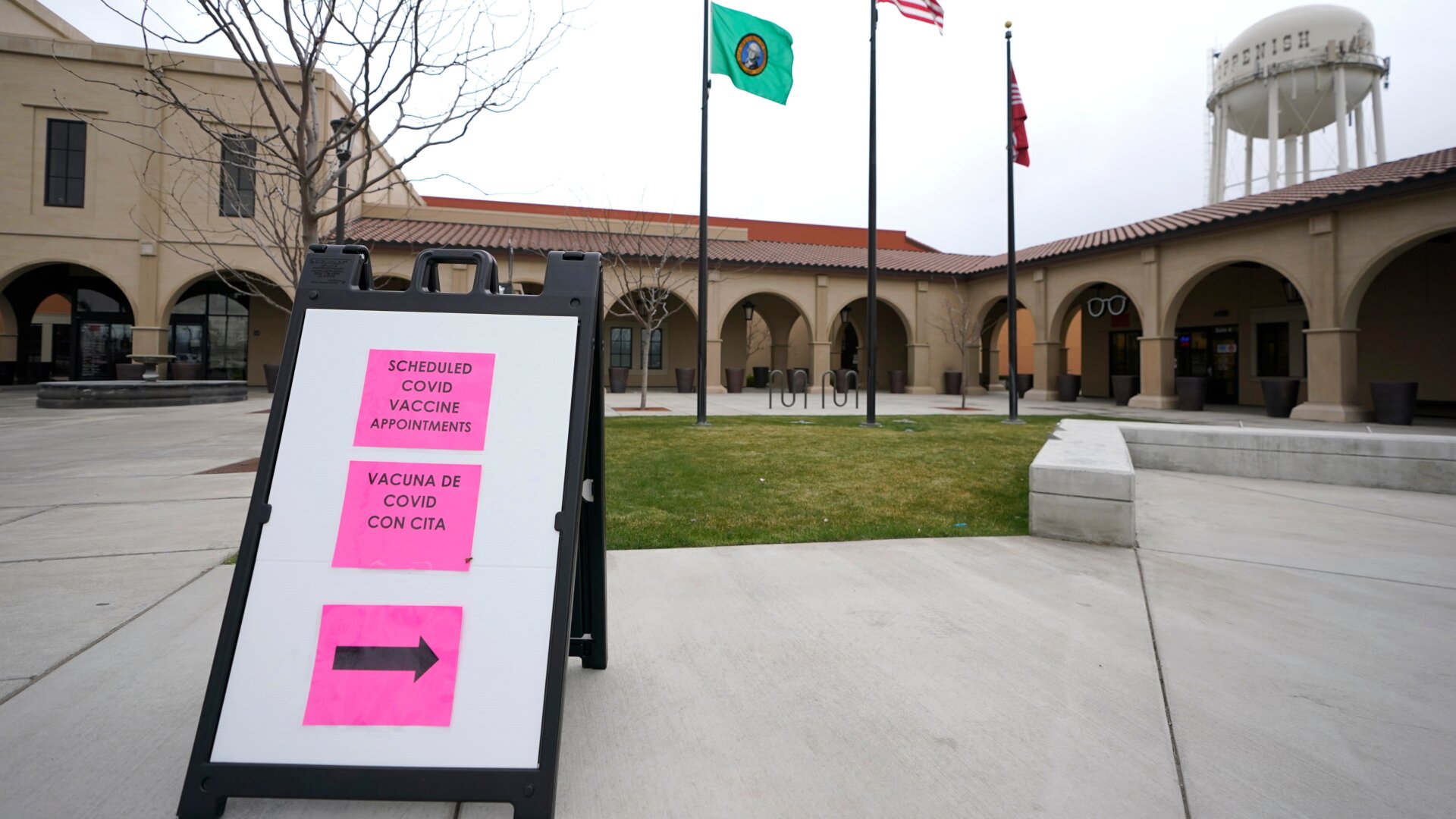 A sign in English and Spanish directs patients to check-in for covid-19 vaccination appointments at the Yakima Valley Farm Workers Clinic in Toppenish, Washington