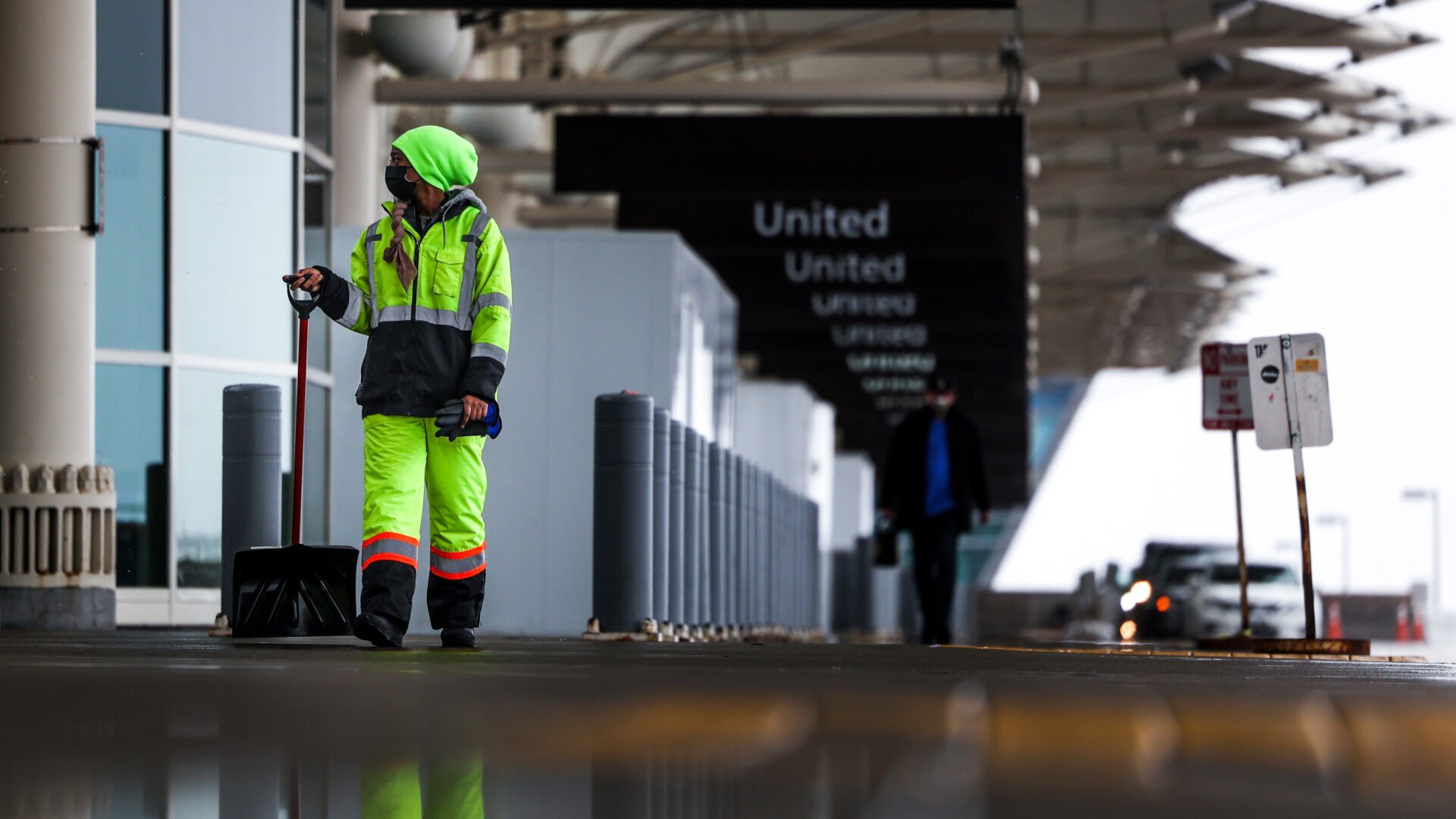  A Denver International Airport employee walks with a shovel in the passenger drop-off area on March 13, 2021 in Denver, Colorado. 
