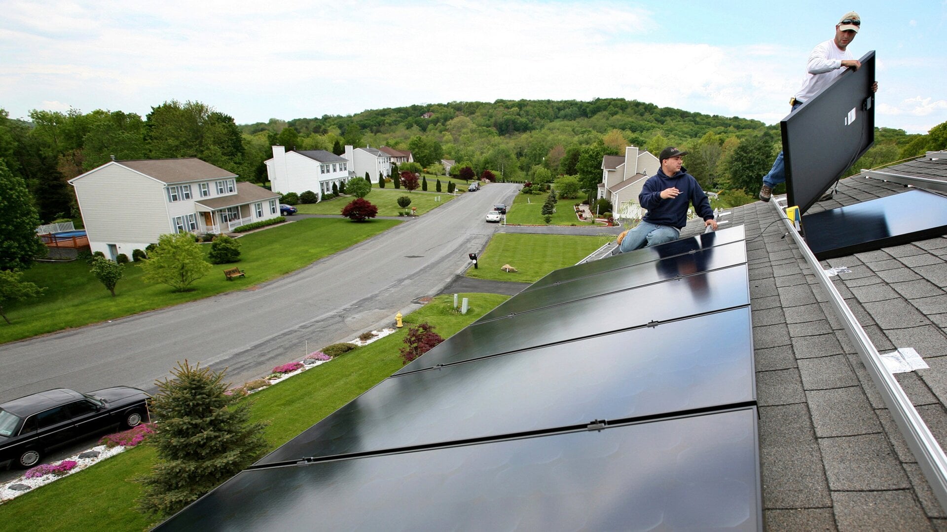 Workers install panels on the roof of a home in Newburgh, New York.