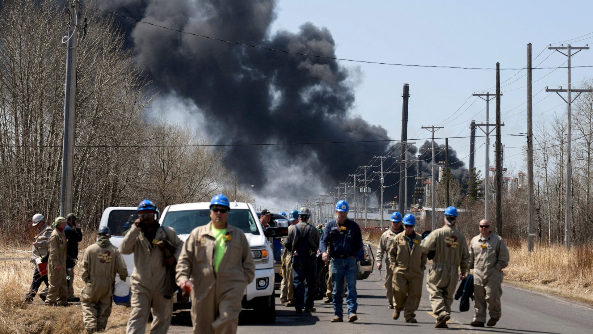 Workers evacuate from an explosion and fire at the Husky Energy oil refinery in Superior, Wisconsin on April 26, 2018. Several people were injured by the explosion and fire at the oil refinery, sending thick plumes of black smoke into the sky as authorities urged residents in the area to evacuate.