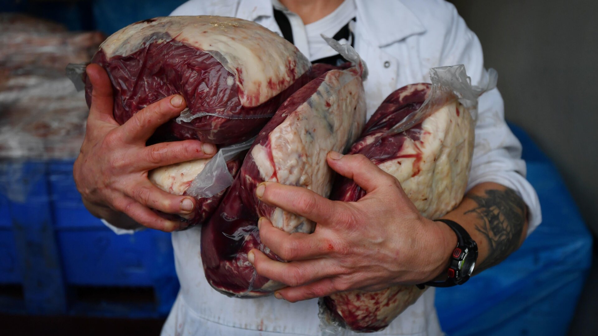 A butcher carries out rump steak cuts.
