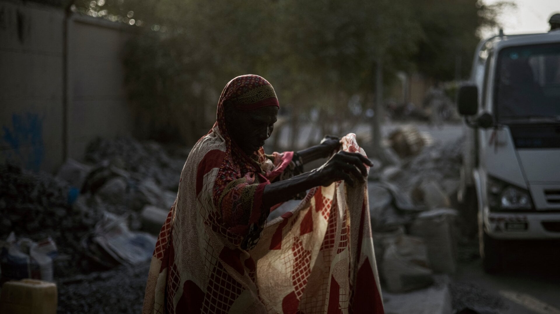 A woman working as a grave crusher adjusts her dress at a site near the Cite International des Affaires in N’Djamena, on April 12, 2021.