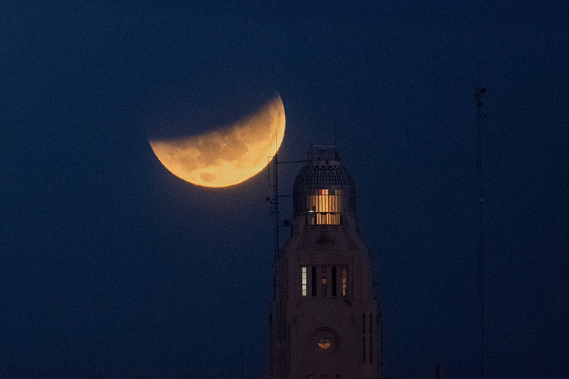 The moon sets behind the Montevideo port, in Uruguay, Wednesday, May 26, 2021.