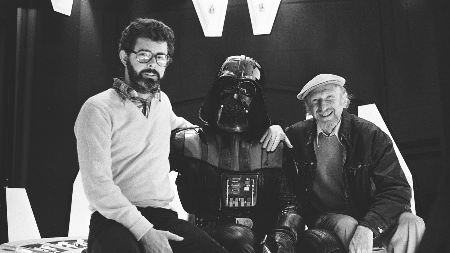 Today is George Lucas’ birthday, seen here with Empire Strikes Back director Irvin Kershner and some guy in a black suit.