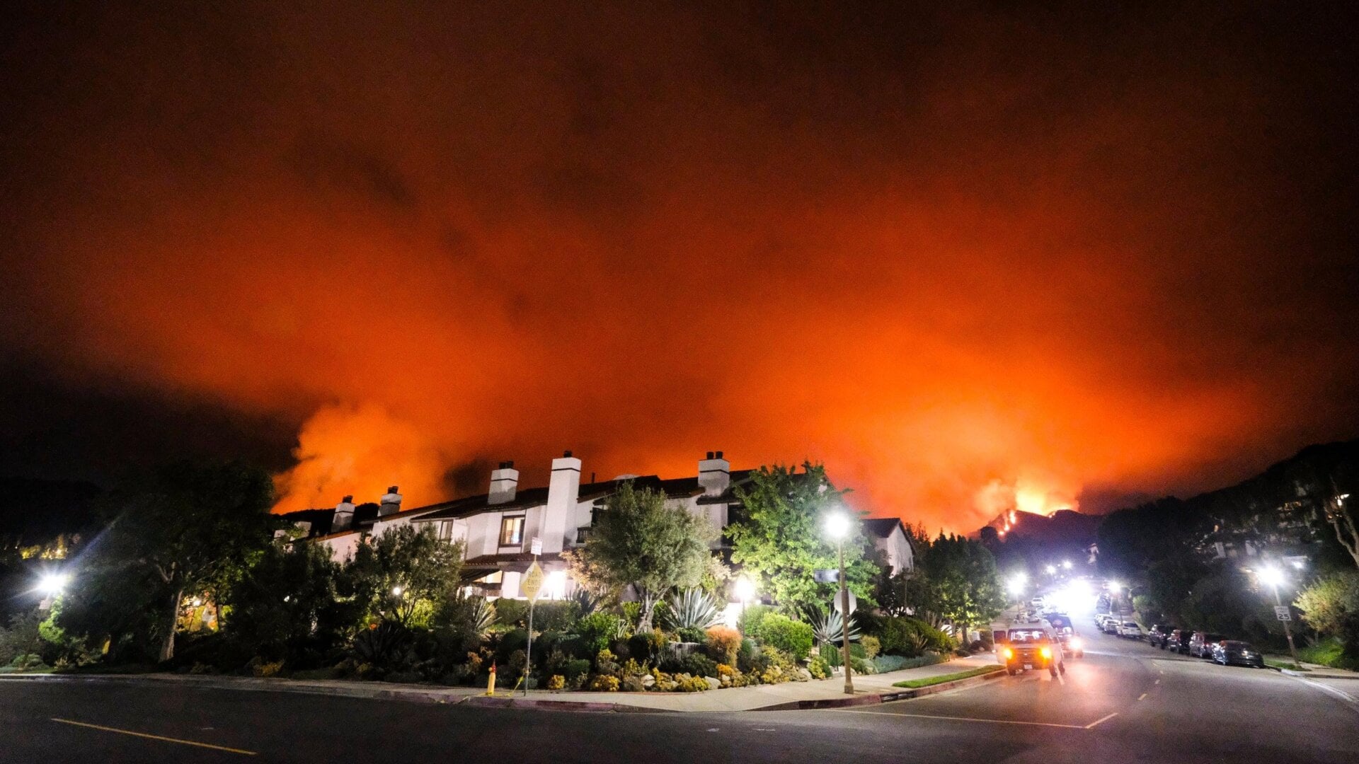 Smoke rising from a brush fire behind homes in the Pacific Palisades area of Los Angeles Saturday, May 15.