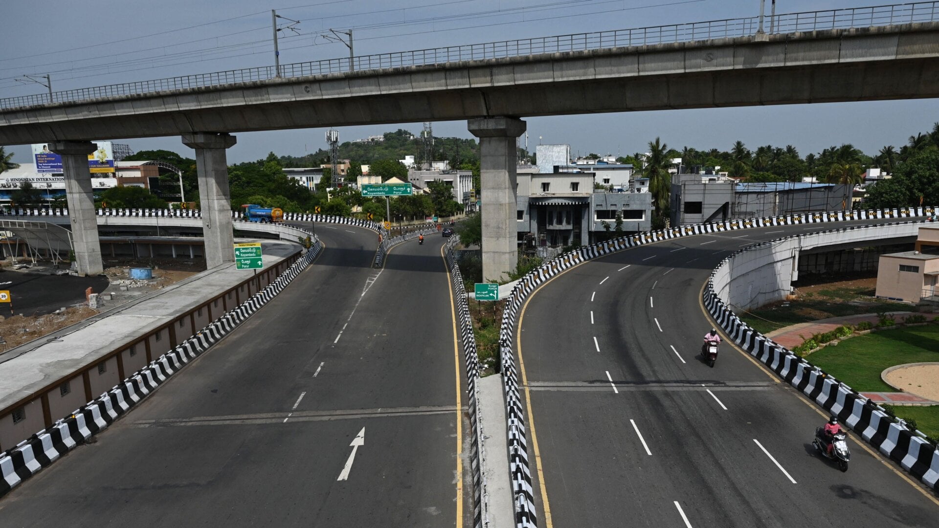 Motorists make their way through a partially deserted road after a complete lockdown was imposed by the state government  in Chennai on May 24, 2021.