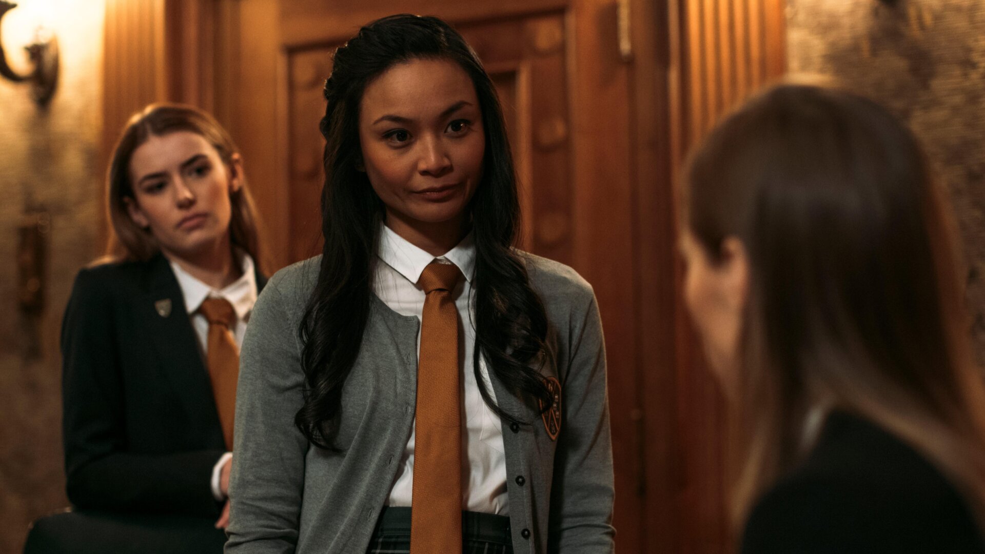 Yvonne (Stephanie Sy) taunts the new girl, Camille (Suki Waterhouse),