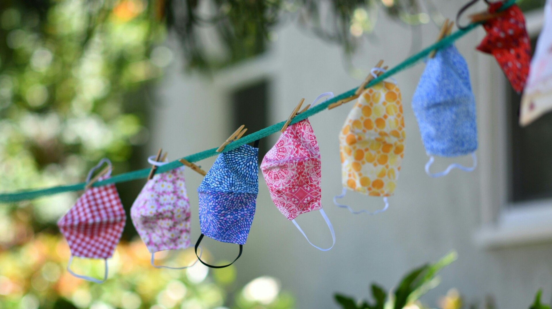For sale masks are seen displayed on a clothesline in the front yard of a house in Los Angeles on July 20, 2020.