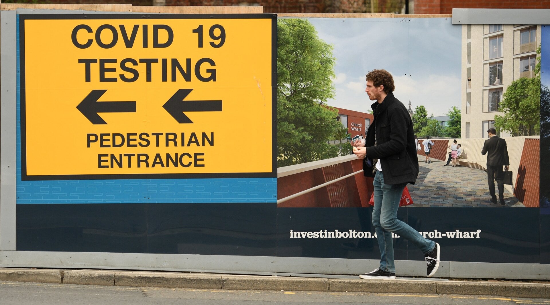 A pedestrian walks past a sign directing members of the public to a covid-19 testing center in Bolton, England, on May 28, 2021.