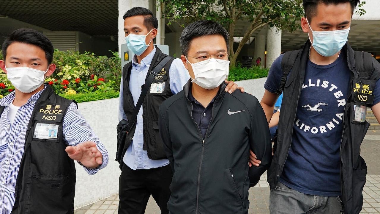 Ryan Law, second from right, Apple Daily’s chief editor, is arrested by police officers in Hong Kong Thursday, June 17, 2021.