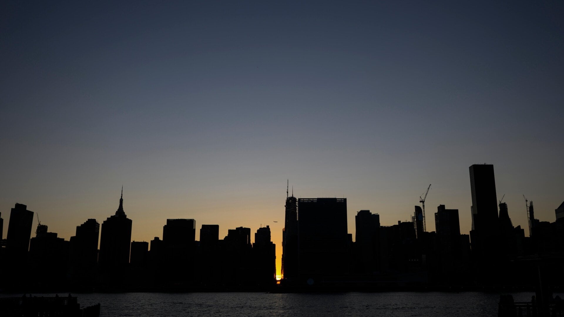 The sun sets behind 42nd Street in Manhattan during a power outage in New York City on July 13, 2019. A similar scene could play out on Wednesday as extreme heat strains the grid.