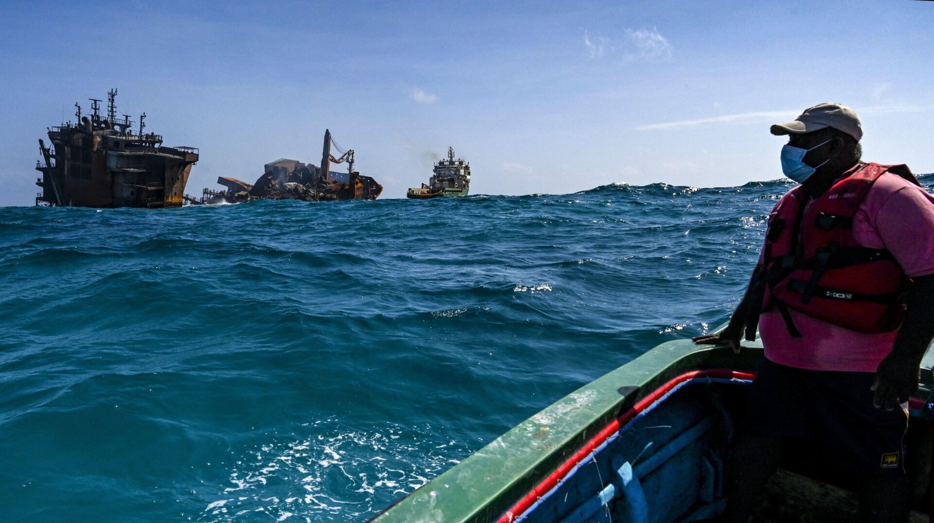 A boatman looks at the MV X-Press Pearl while the ship sinks away from the coast of Colombo on June 2.