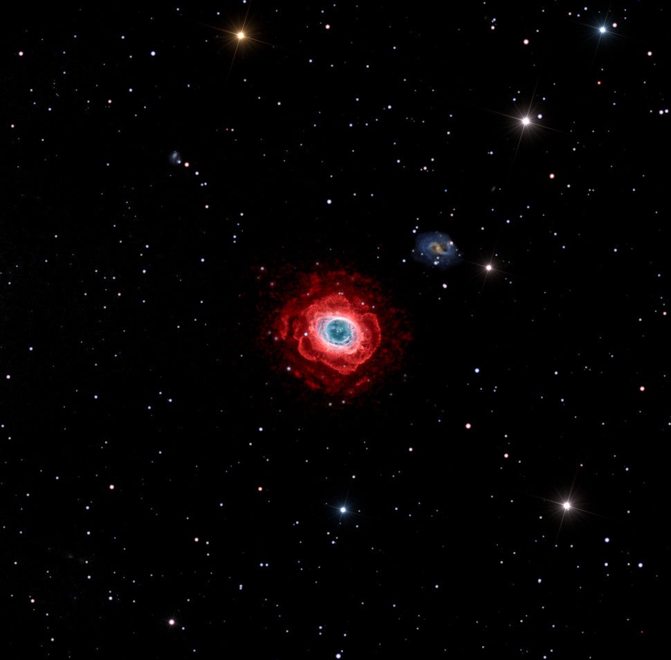 A deep view of the Messier 57 nebula. Note the distant galaxy in the background. 