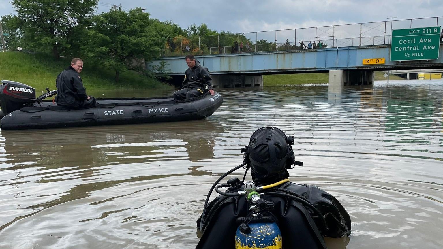 A Michigan State Police diver on the highway after heavy rains inundated the Detroit area.