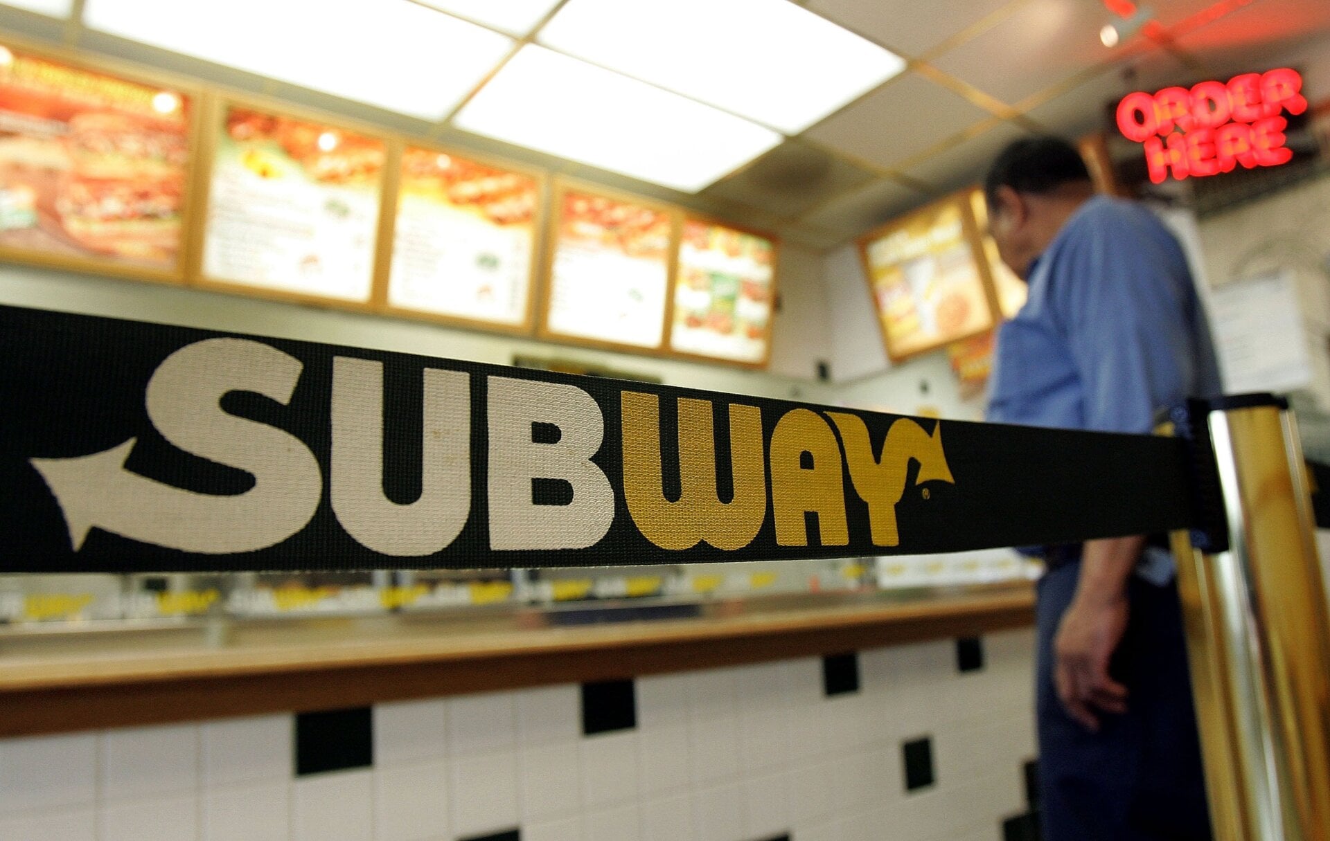 A person stands near signage while inside a Subway restaurant June 6, 2005, in Chicago, Illinois.