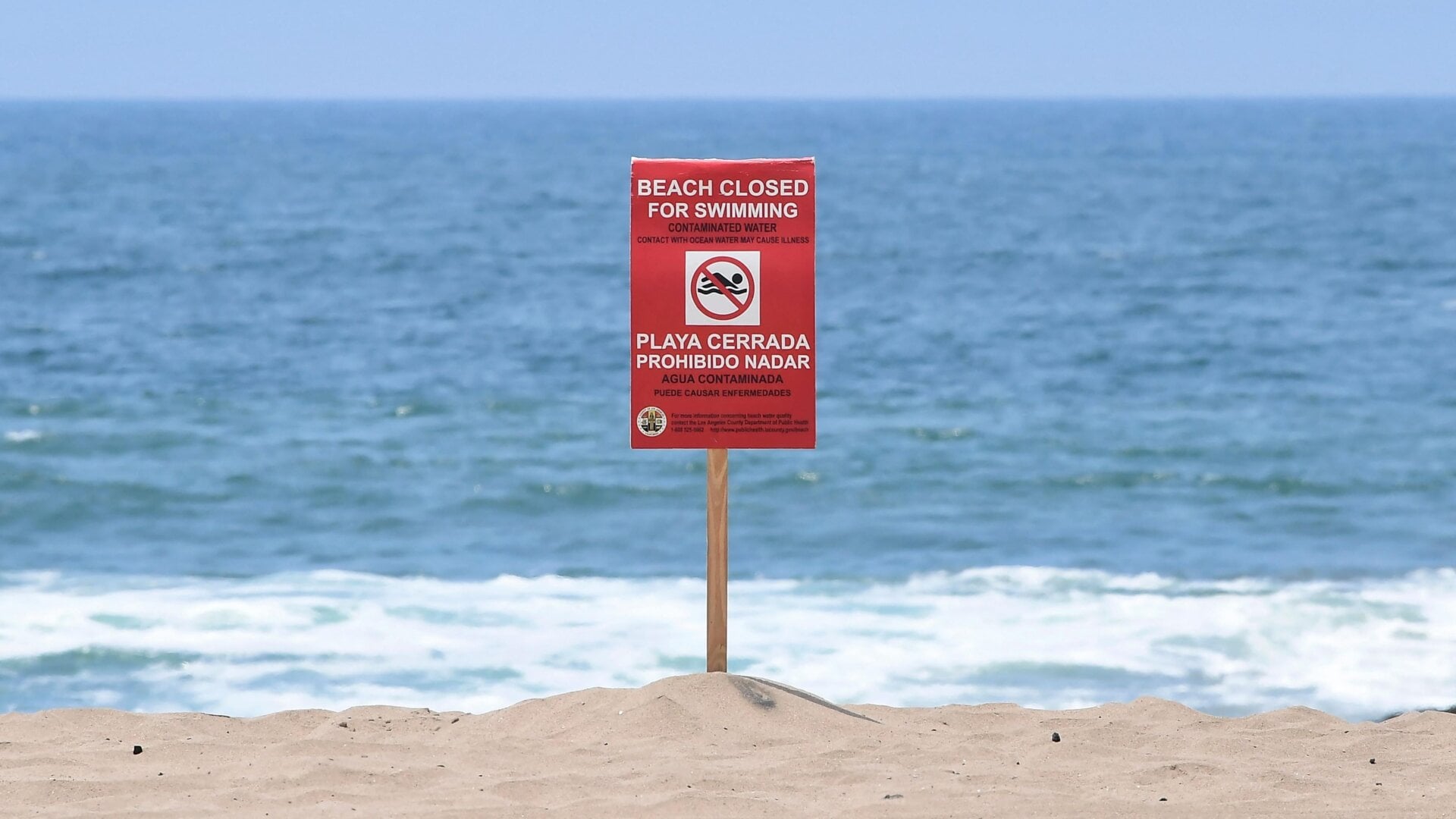 A sign indicates that the Dockweiler State Beach is closed to swimming after a sewage spill in Playa del Rey, in Los Angeles County, California.