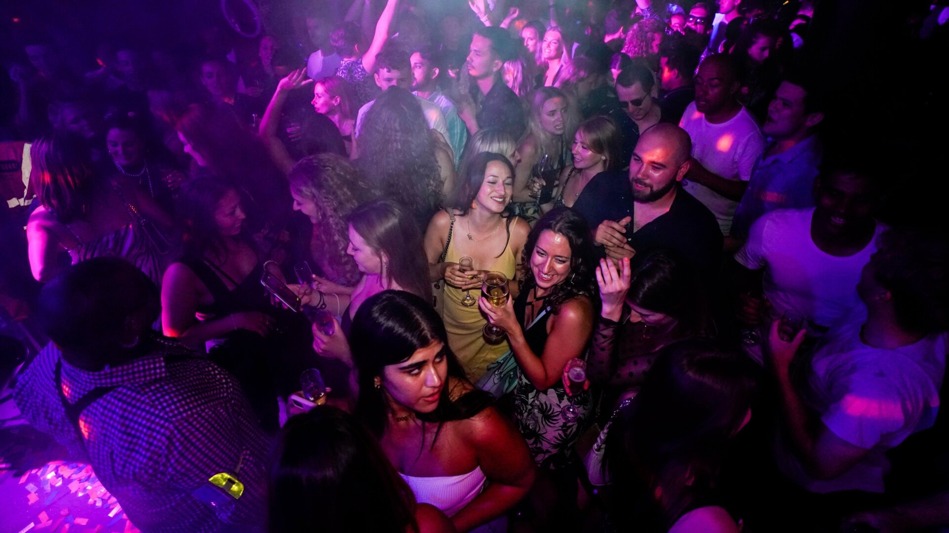 People drink on the dance floor shortly after the midnight reopening of The Piano Works in Farringdon, in London, Monday, July 19, 2021.