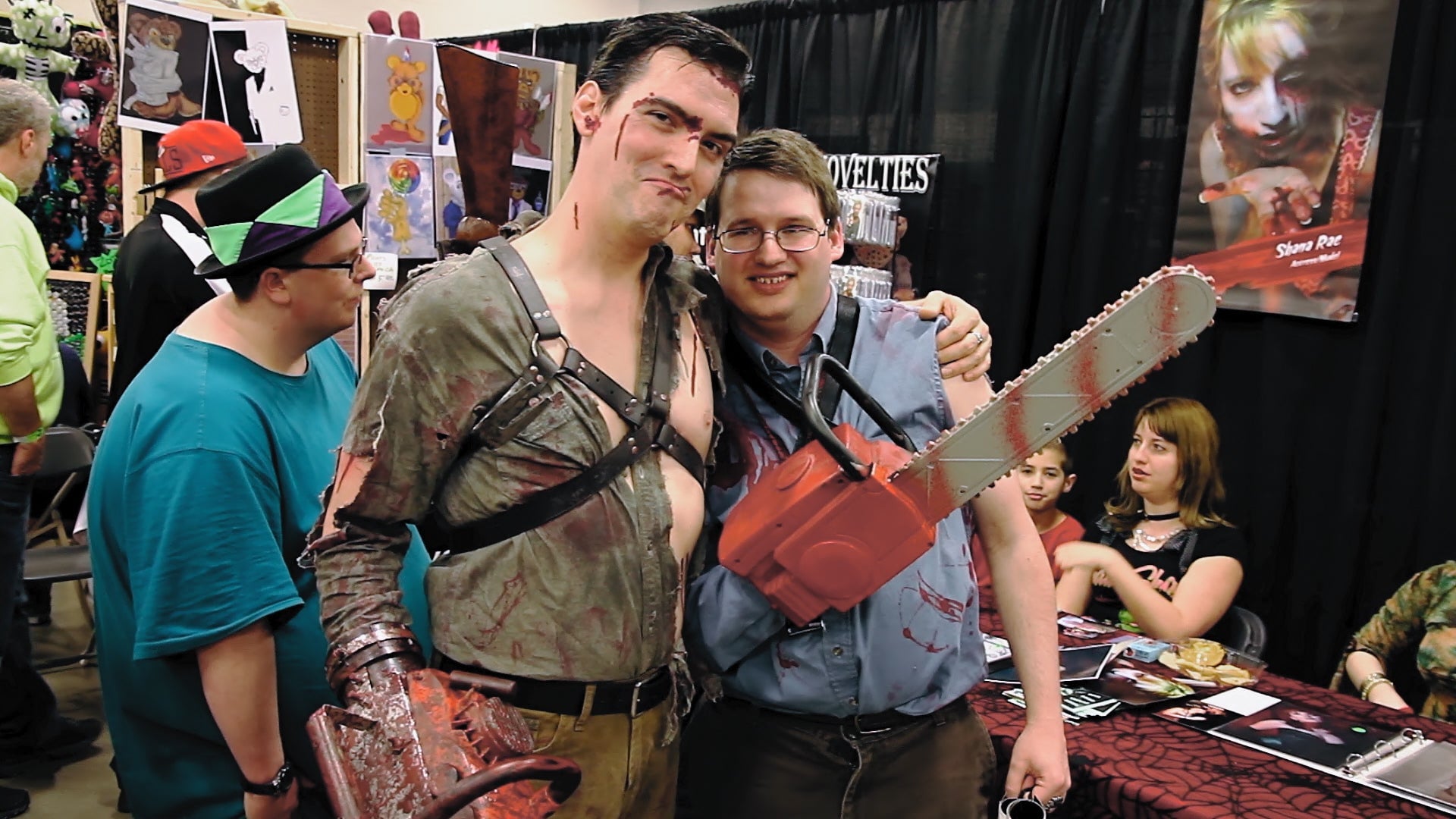 A cosplayer dressed as Ash poses with an admirer at a horror convention.