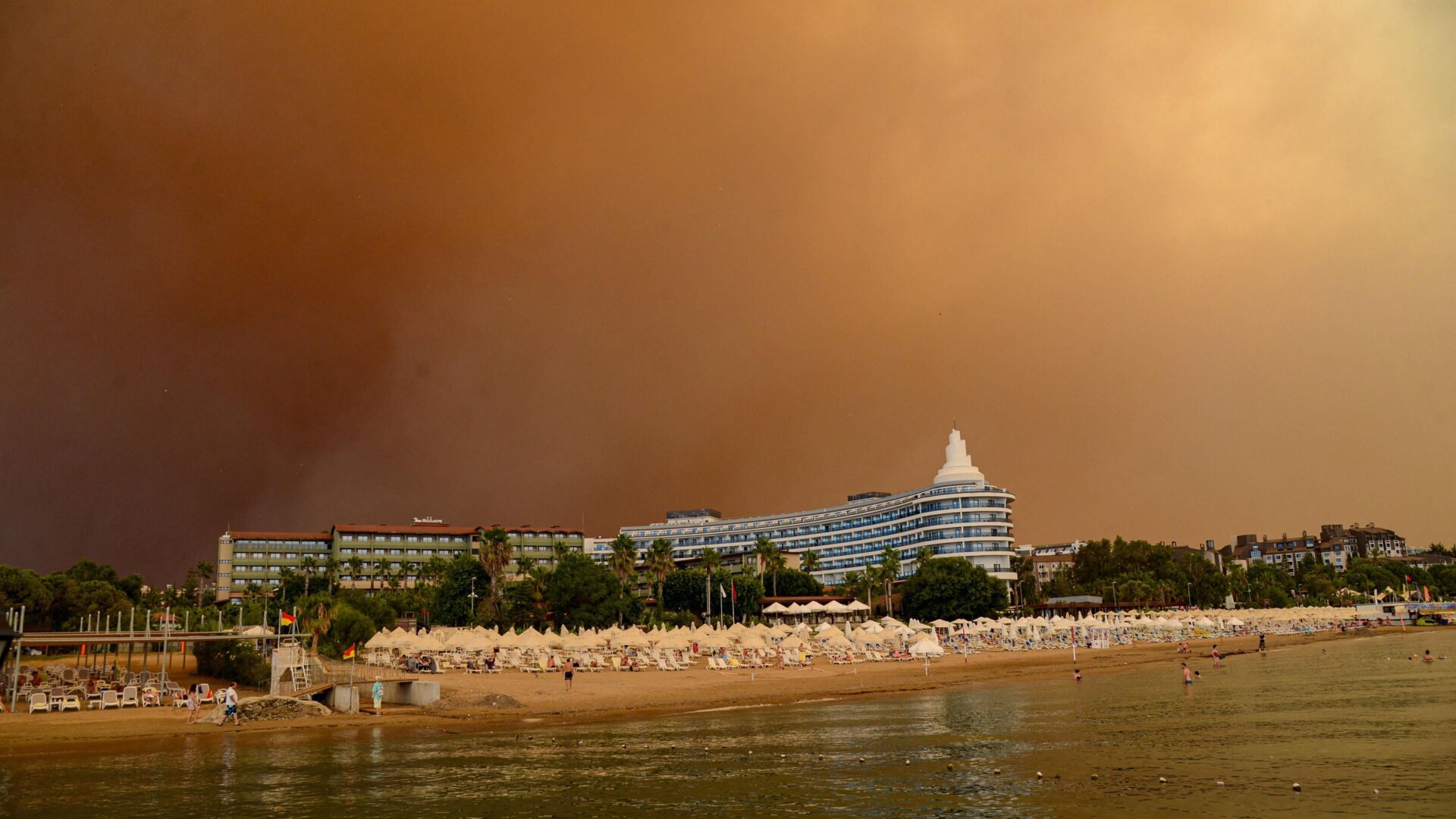 Dark smoke drifts over a hotel complex during a massive forest fire, which engulfed a Mediterranean resort region on Turkey’s southern coast near the town of Manavgat, on July 29, 2021.