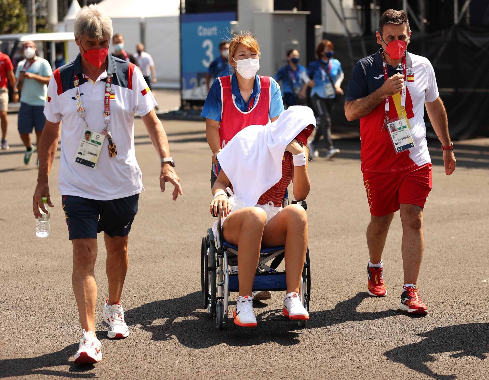 Paula Badosa of Team Spain is helped away from the court in a wheelchair after having to retire from her Women’s Singles Quarterfinal match against Marketa Vondrousova of Team Czech Republic on day five of the Tokyo 2020 Olympic Games at Ariake Tennis Park on July 28, 2021 in Tokyo, Japan.