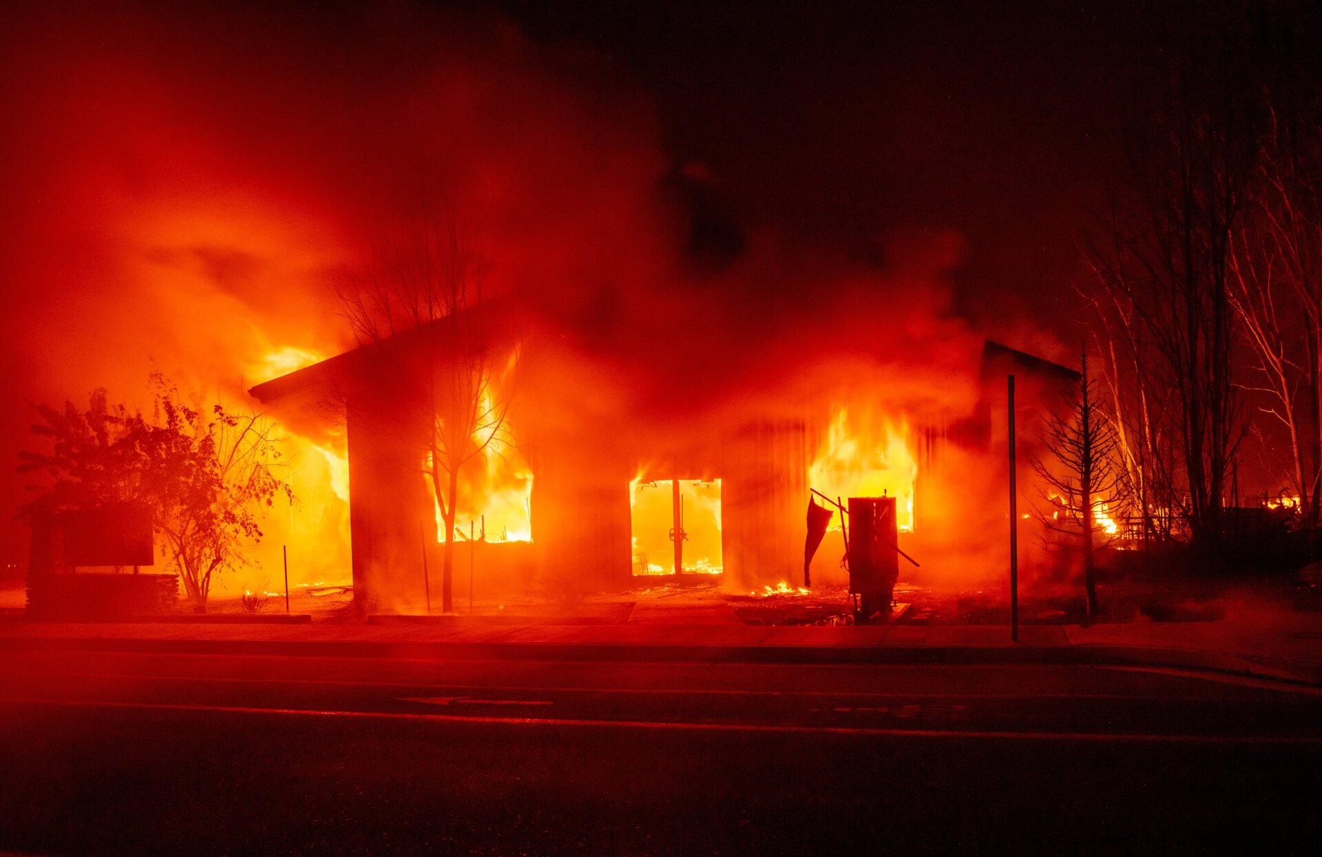 A structure burns as flames from the Dixie Fire tears through downtown Greenville, California.
