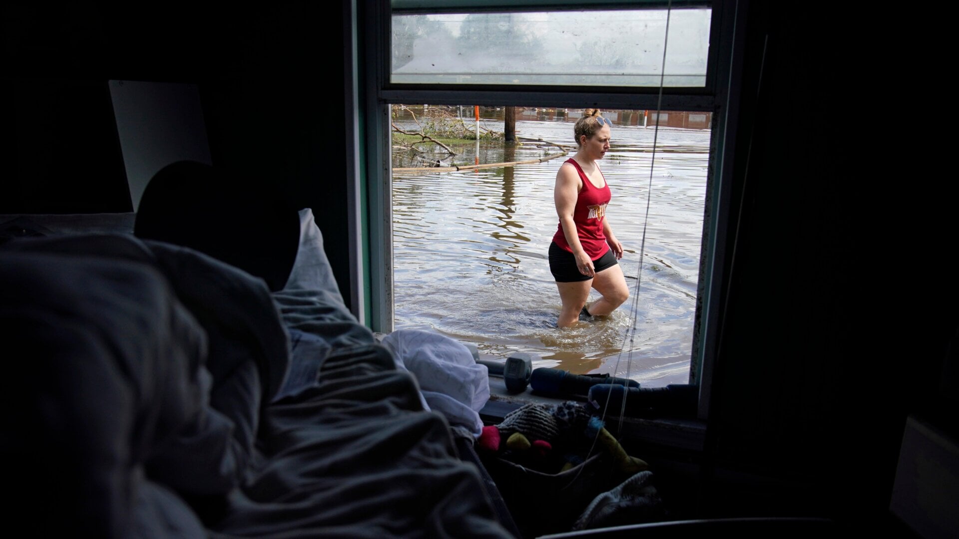 Emily Francois walks through floodwaters beside her flood damaged home in the aftermath of Hurricane Ida, Wednesday, Sept. 1, 2021, in Jean Lafitte, Louisiana.