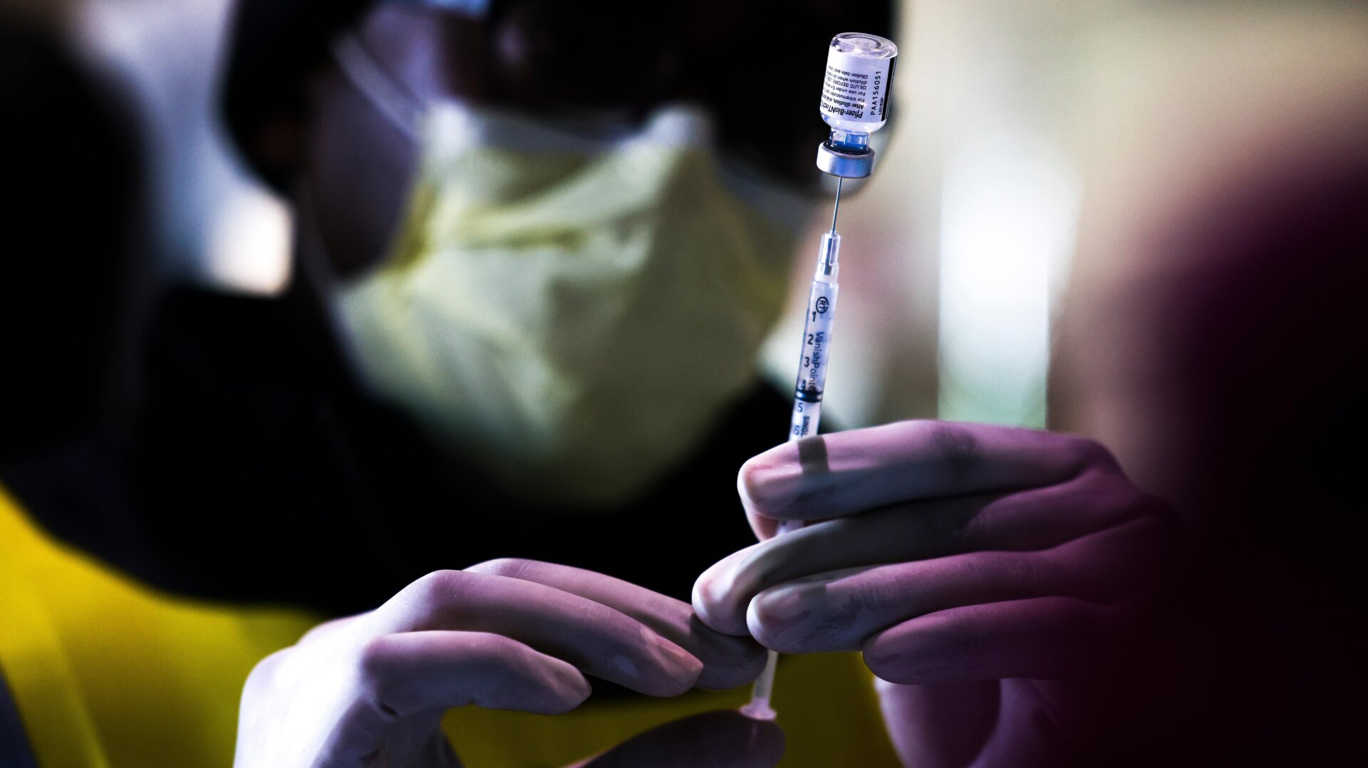 Pharmacy technicians prepare doses of the Pfizer-BioNTech vaccine at a mass COVID-19 vaccination event on January 30, 2021 in Denver, Colorado.