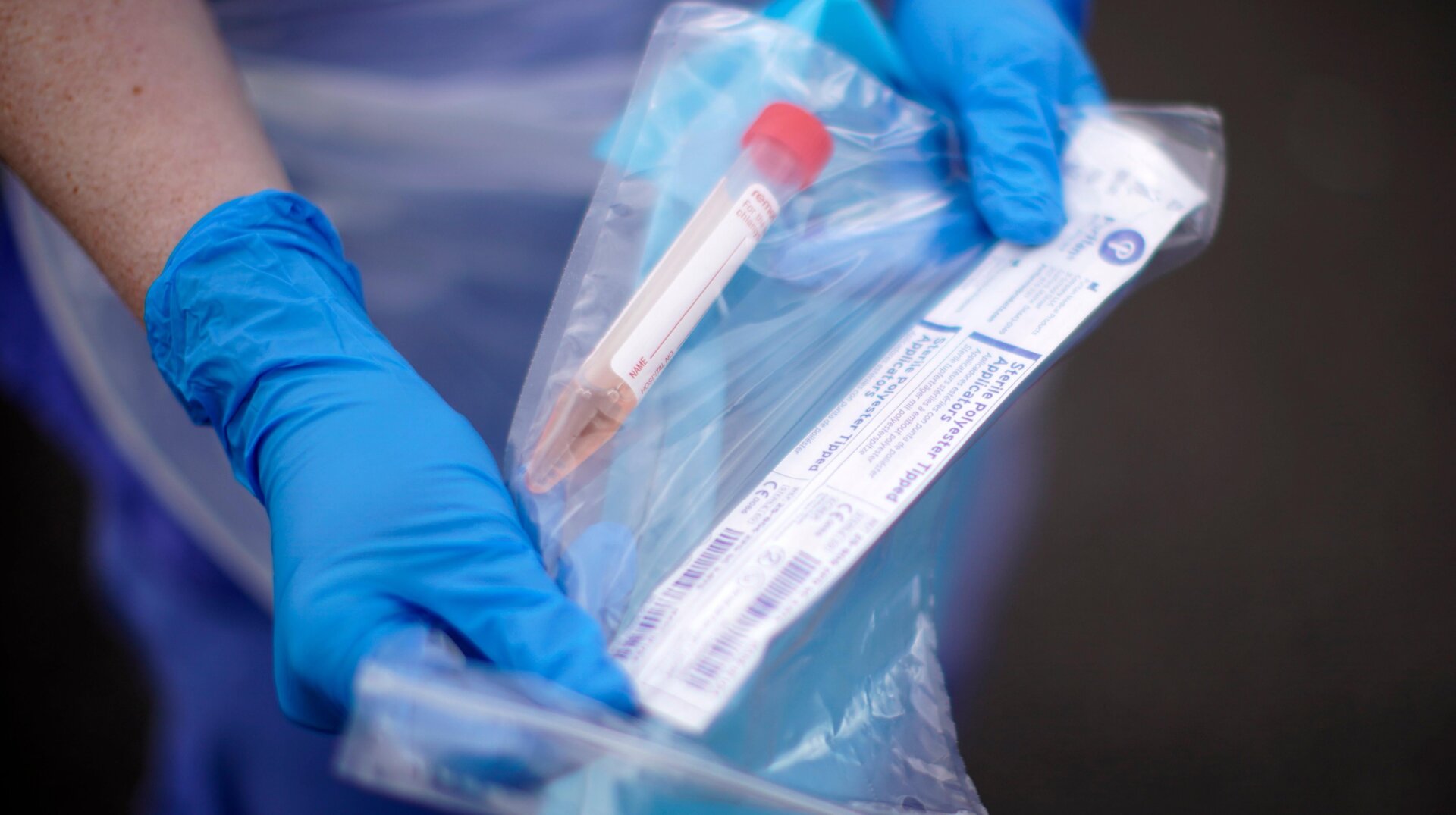 A NHS nurse holds a Coronavirus testing kit as she speaks to the media at a drive through Coronavirus testing site in a car park on March 12, 2020 in Wolverhampton, England.