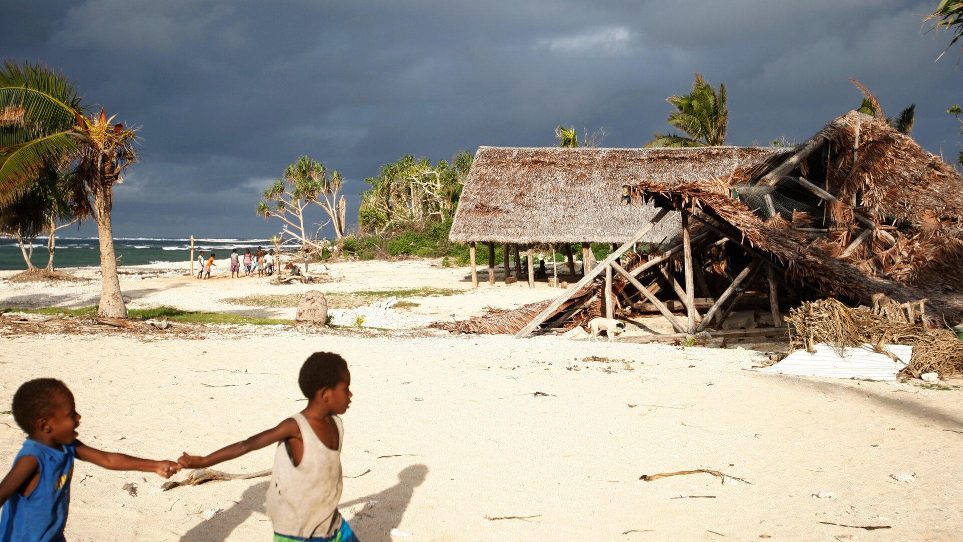 In this Saturday, May 30, 2015, photo, children play on the beach in the town of Takara, on Efate Island, Vanuatu. The town was damaged during Cyclone Pam.