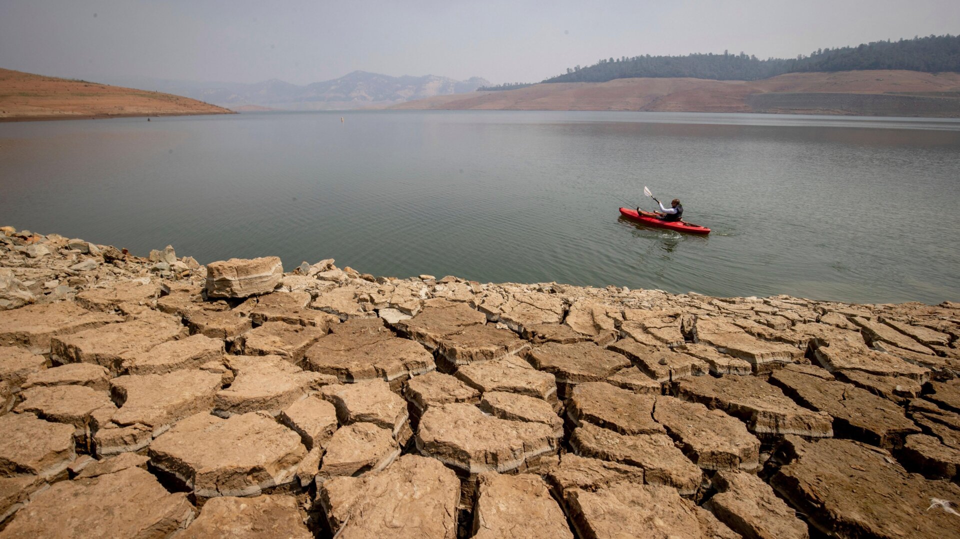 A kayaker fishes in Lake Oroville as water levels remain low due to continuing drought conditions in Oroville, California.