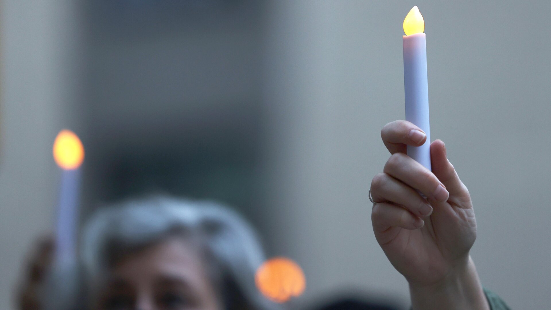 People hold up electric candles during a prayer vigil for victims of the covid-19 pandemic on October 19, 2020 in New York City.
