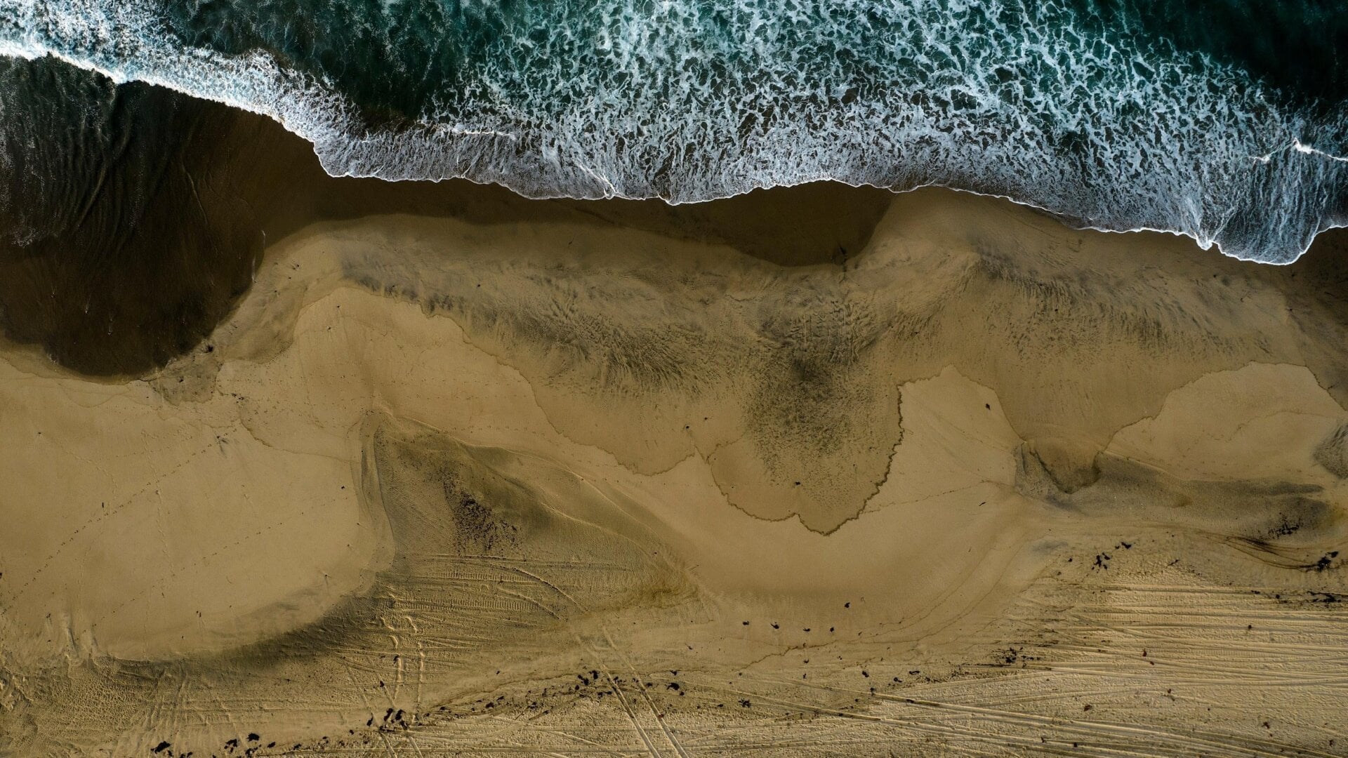 An aerial photo shows the closed beach after oil washed up on Huntington Beach, Calif., on Monday, Oct. 4, 2021.