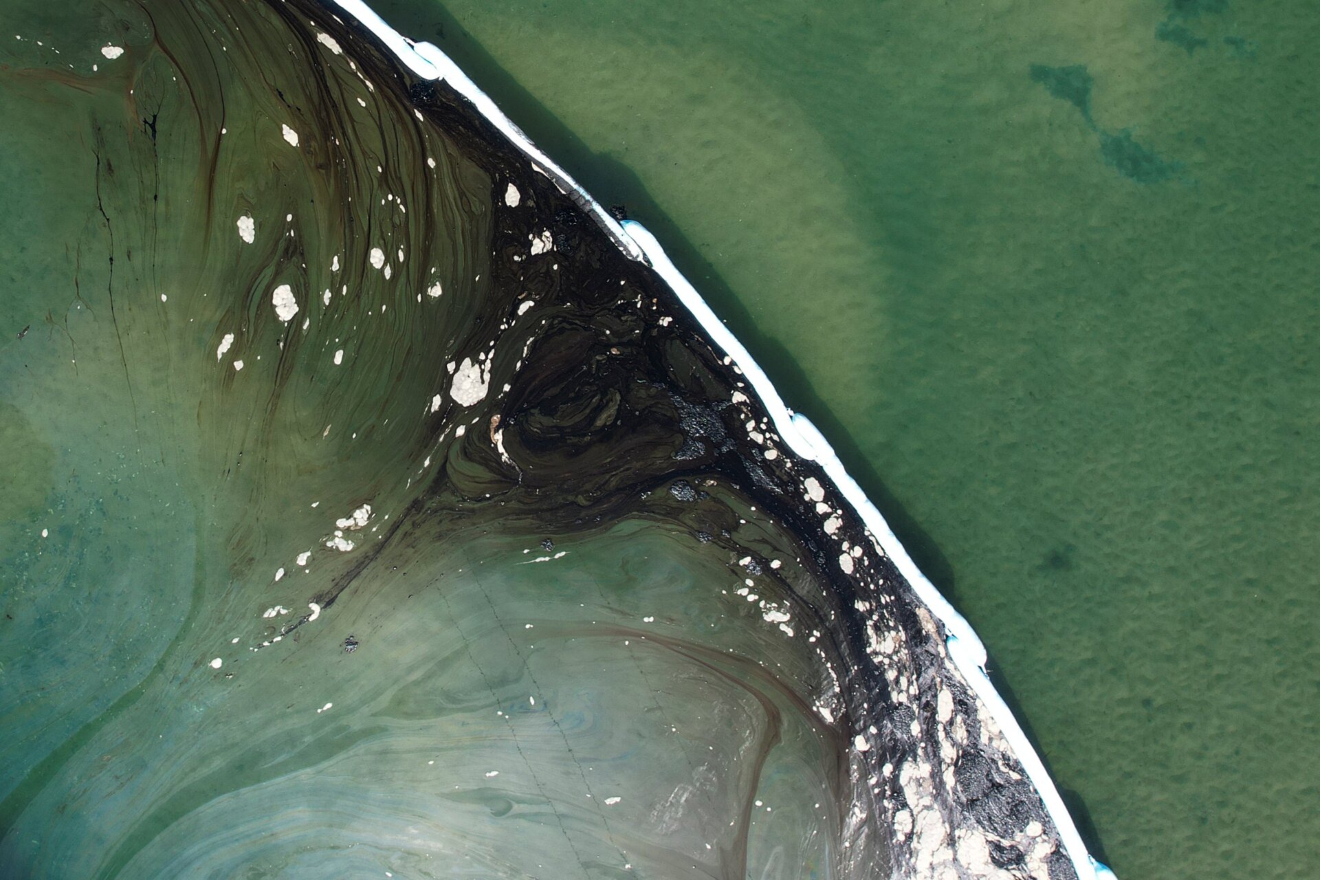 Floating barriers known as booms to try to stop oil from further entering the Talbert Marsh wetlands.