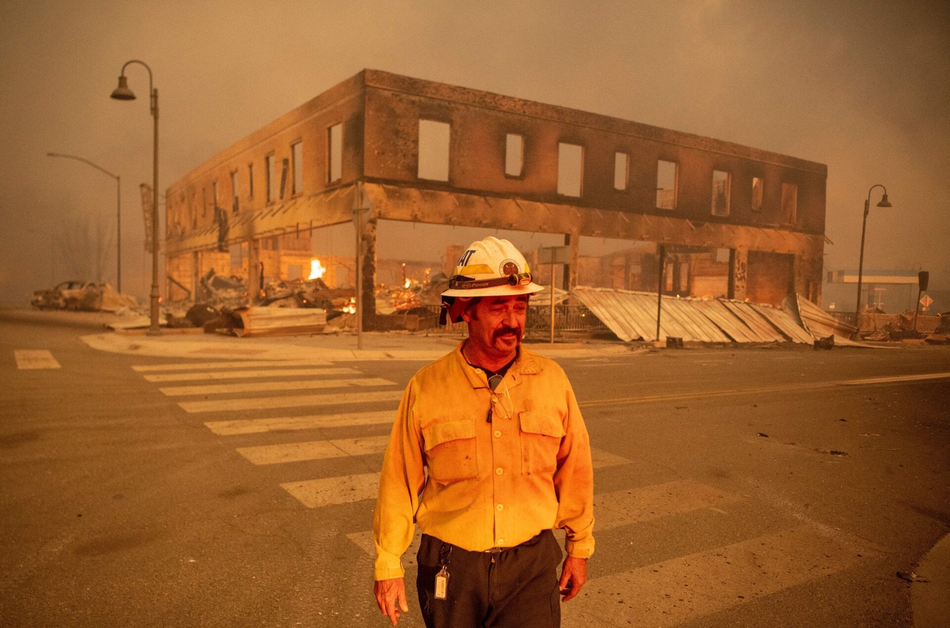 Battalion Chief Sergio Mora looks on as the Dixie fire burns through downtown Greenville, California, on Aug. 4, 2021.
