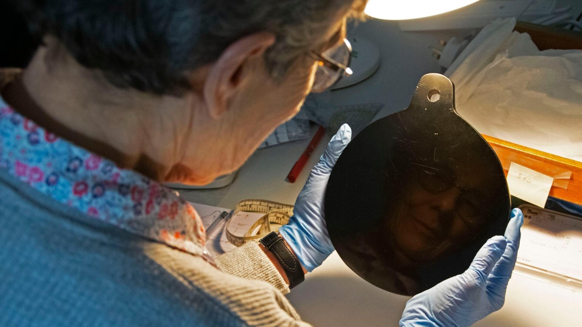 Study co-author Elizabeth Healey examining the obsidian mirror.