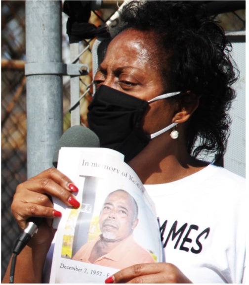 Lavigne speaks at a protest at the Army Corps of Engineers office in New Orleans. She is holding a photograph of a fellow advocate, Keith Hunter, who died of a sudden respiratory illness.
