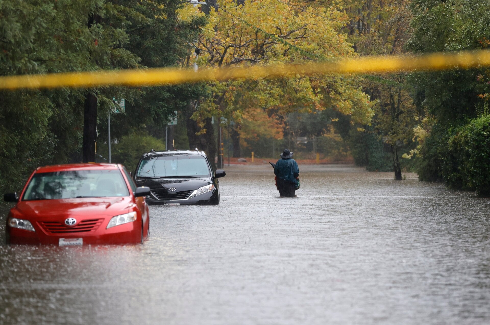 A pedestrian walks on a flooded street on October 24, 2021 in Kentfield, California.